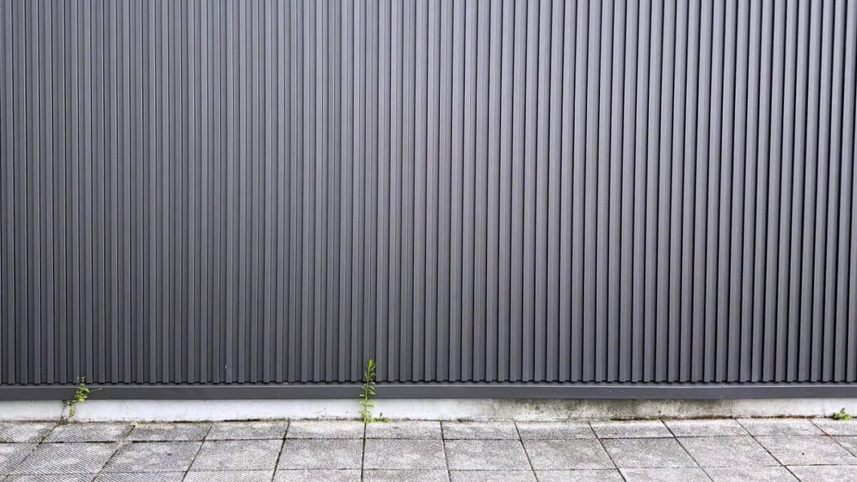縦に溝の入った金属の外壁材を張った家の壁